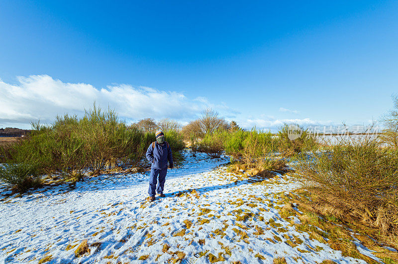 一名老年男子在一年中非高峰时期的一次降雪后探索农村地区