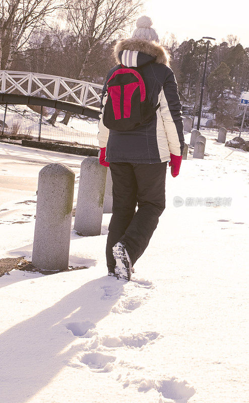 一个女孩背着背包走过城市公园。健康的生活方式。心理平衡。