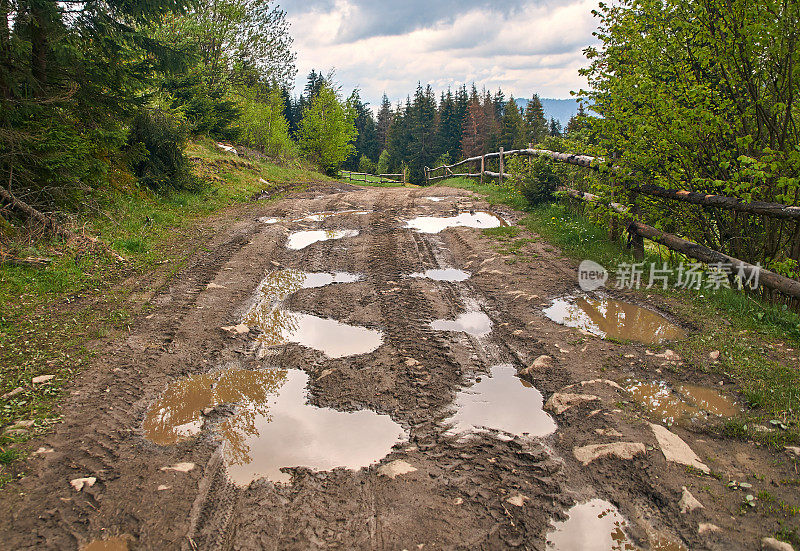 春山中破碎的乡村土路，雨后有许多泥泞的水坑