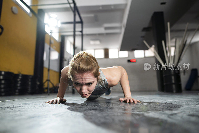 专注的女运动员在健身房做俯卧撑
