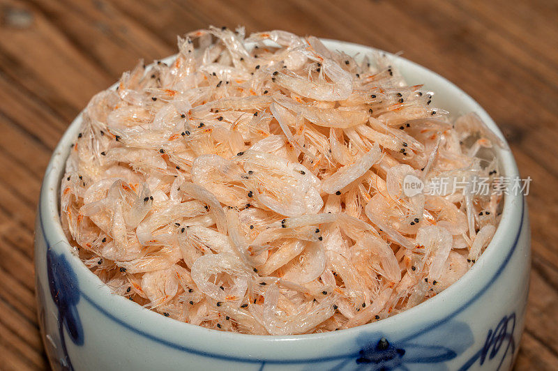 碗或盘子里的干虾子放在木桌上。
