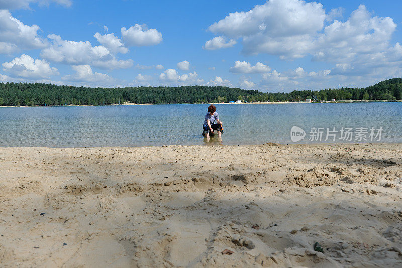 一个女人正在森林湖里洗她的脏脚和凉鞋