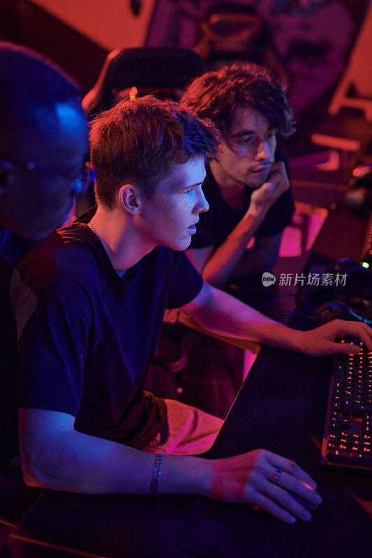 年轻玩家围坐在霓虹灯间，讨论电子游戏的策略