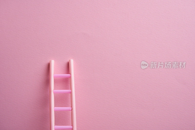 粉红色背景上的梯子