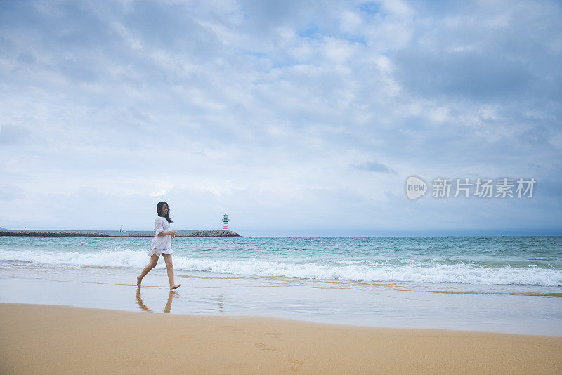 年轻女子在沙滩上奔跑