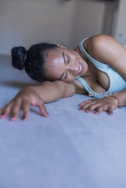 一位非洲裔妇女在她的健身房里做瑜伽