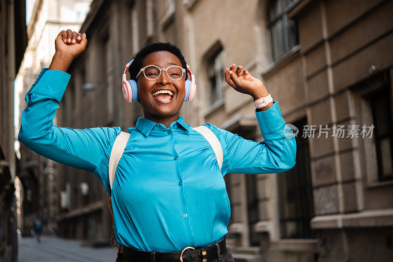 快乐的非洲女孩坐在街上，享受着音乐