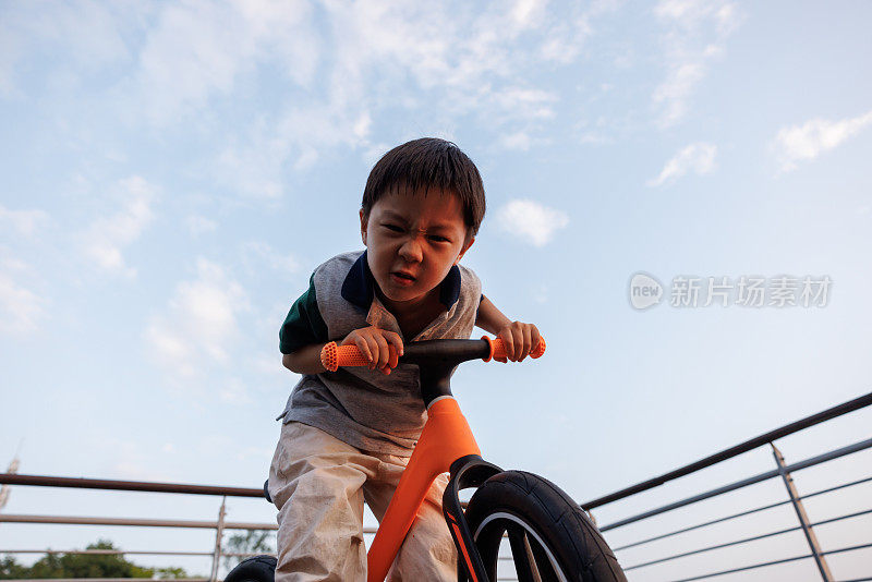 这个小男孩正在学骑自行车