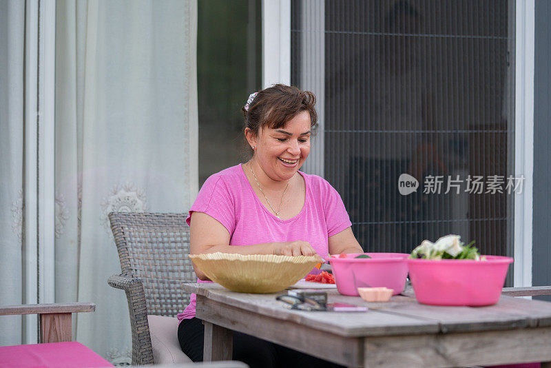 中年妇女在院子里做沙拉做晚餐