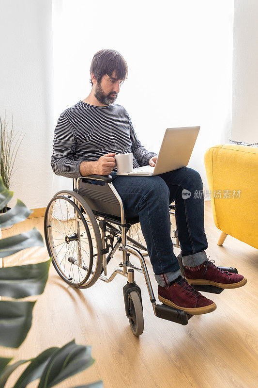 一个坐轮椅的成年人在家用笔记本电脑工作