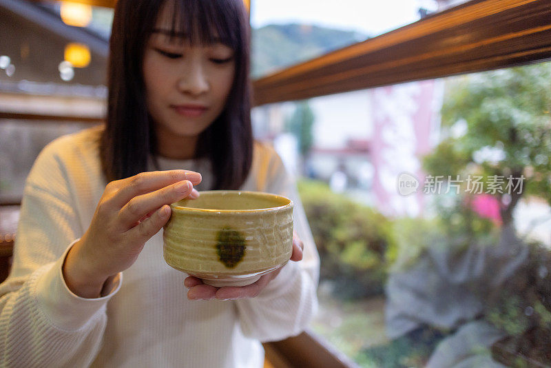 女人擦拭抹茶杯的边缘