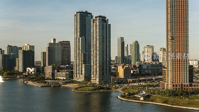 猎人角南公园扩建项目，东河岸边有豪华公寓，后面是长岛市的高楼。