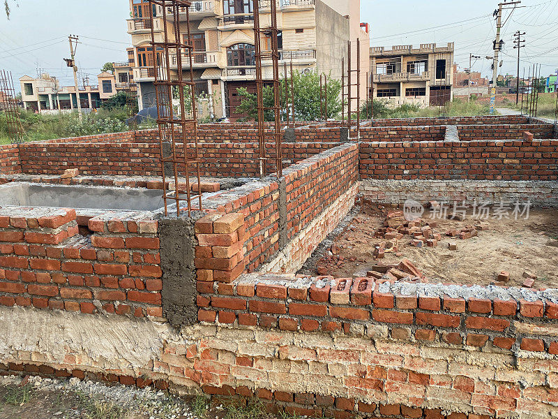 住宅区印度建筑工地的红砖建筑特写图像，房子的红砖基础，部分建成的墙的家，重点在前景