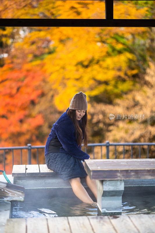 秋天，一名女子在温泉小镇的免费公共温泉足浴中泡脚