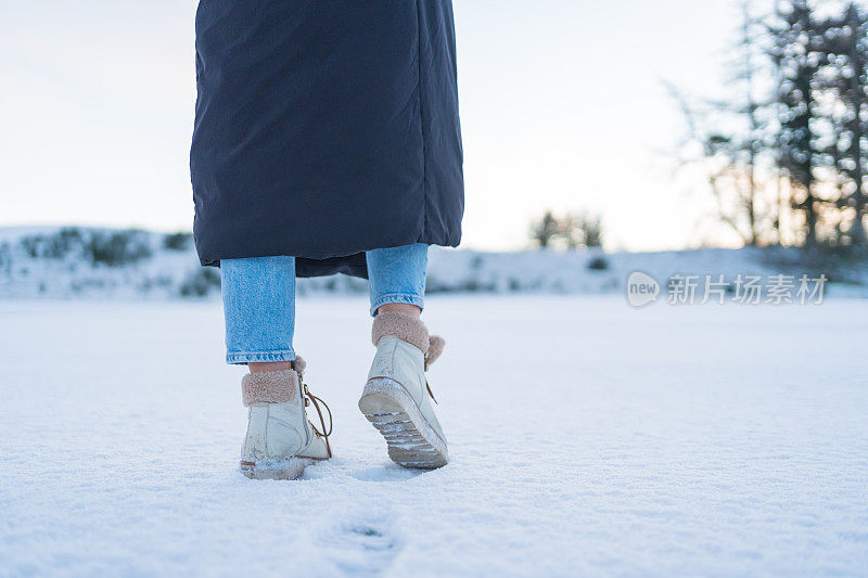 在雪地上的女人的腿的低角度视图