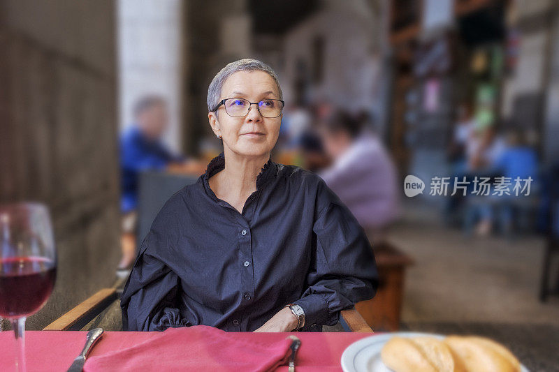 一个成熟的女人在餐厅等待午餐