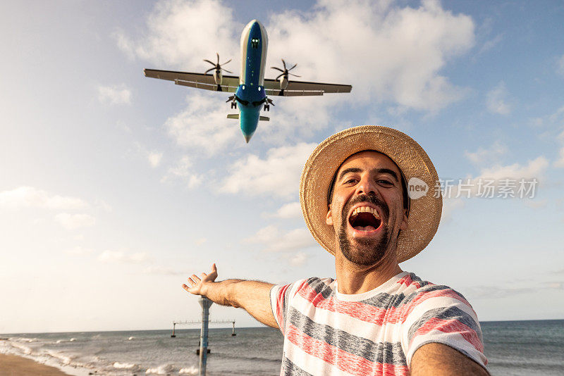快乐的男子在飞机降落的机场自拍