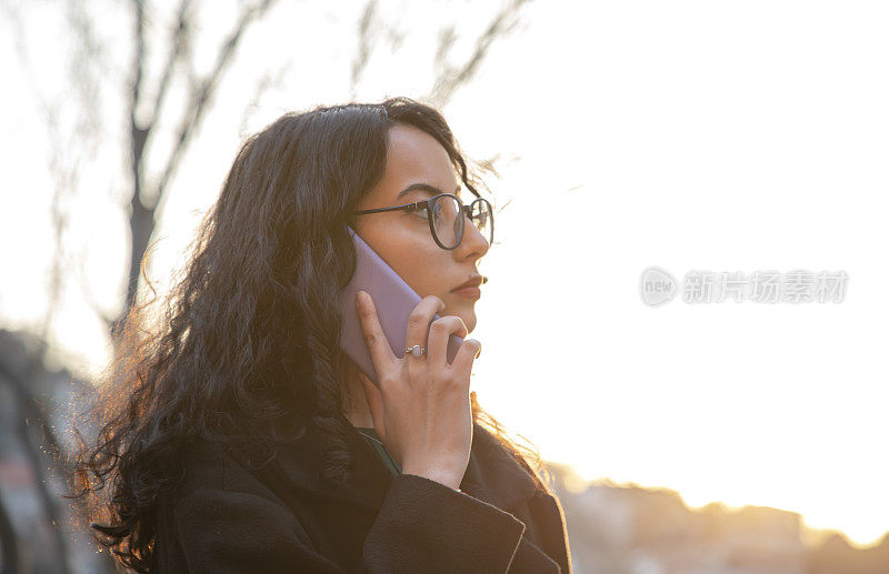 年轻漂亮的深色头发，戴眼镜的女人打电话