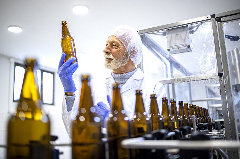 在饮料厂控制啤酒瓶生产的有经验的工人。