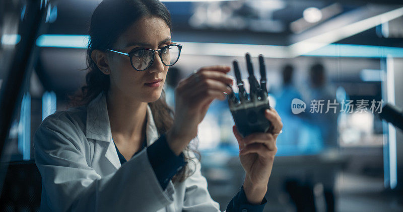 年轻科学家致力于为有健康问题或有缺陷的人研制仿生机器人手。女工程师在一家初创公司使用螺丝刀工作人形人工智能机器人组件