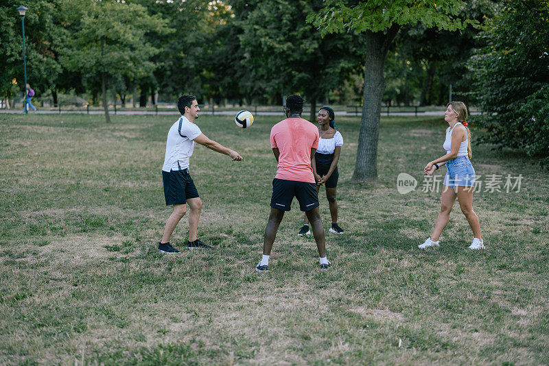 年轻的朋友们在公园里打排球的照片。