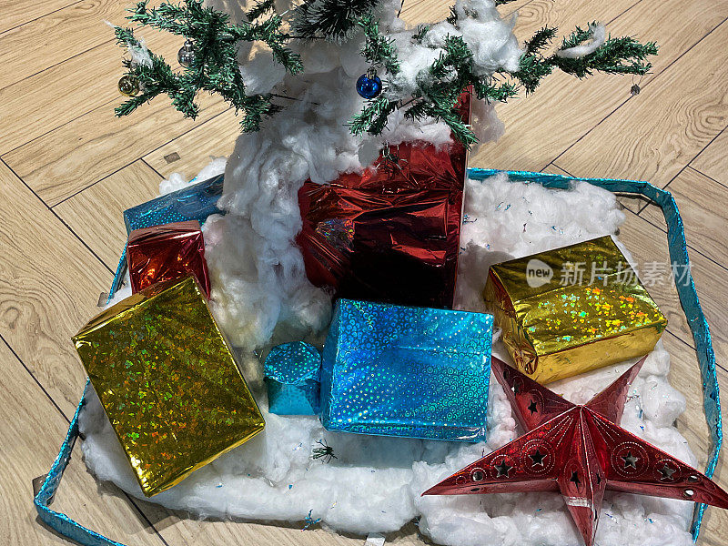 特写形象的人工，装饰圣诞树，节日展示与圣诞礼物，礼品包裹，星形和彩色小饰品，高架视图，重点在前景