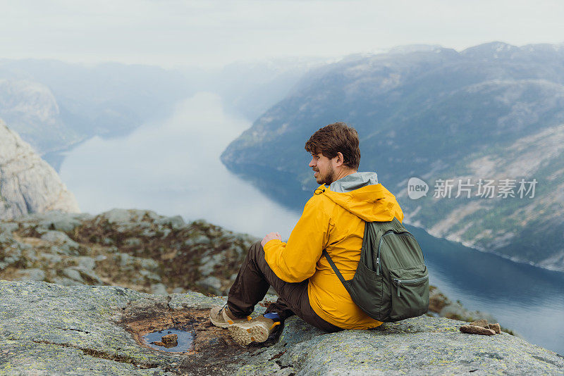 一个快乐的人从挪威风景优美的吕瑟峡湾俯瞰风景