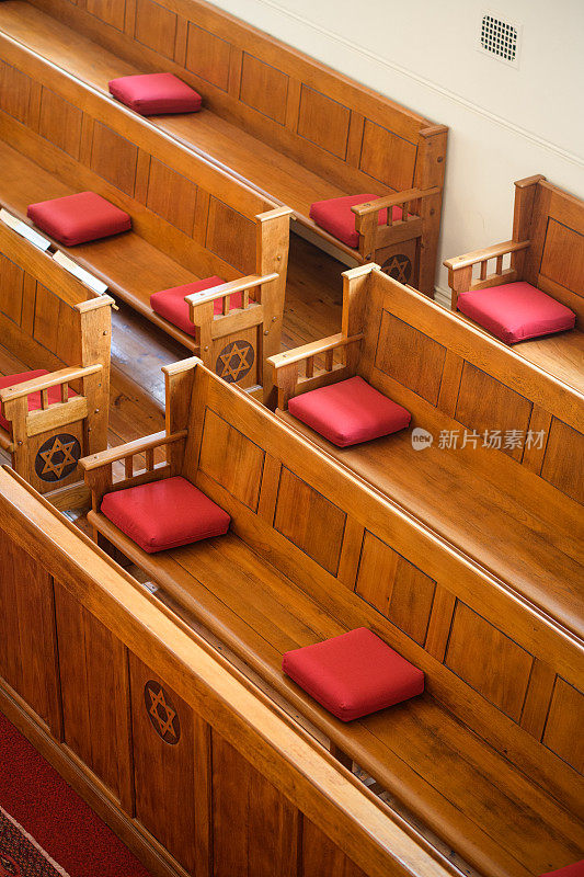 木制的犹太教堂长凳，红色的枕头和大卫之星