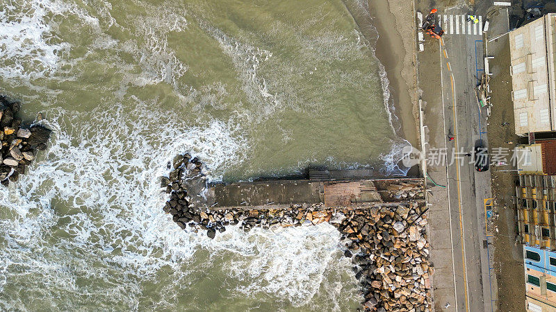 风暴在比萨码头，托斯卡纳。狂暴的海浪拍打着海岸，在阳光明媚的早晨鸟瞰