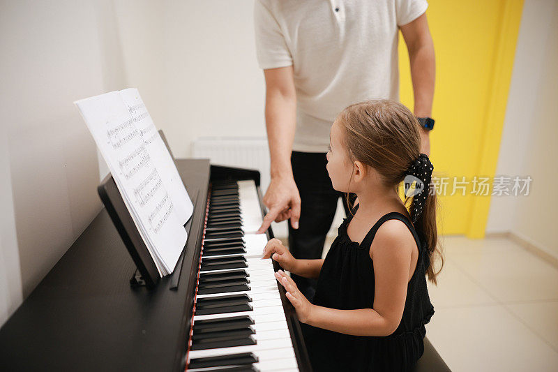 青年钢琴家老师教女童学生弹钢琴、音乐教育的理念