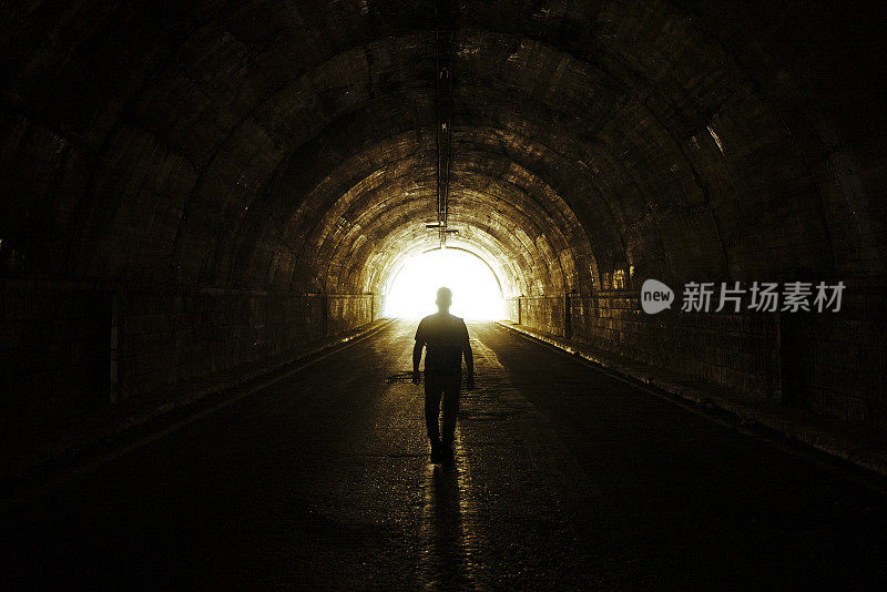 人在隧道中从黑暗走向光明