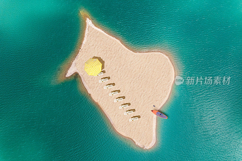 在海上一个无人居住的沙漠小岛上，有很多带伞和冲浪板的甲板椅。无人机视图，鸟瞰图，俯视图