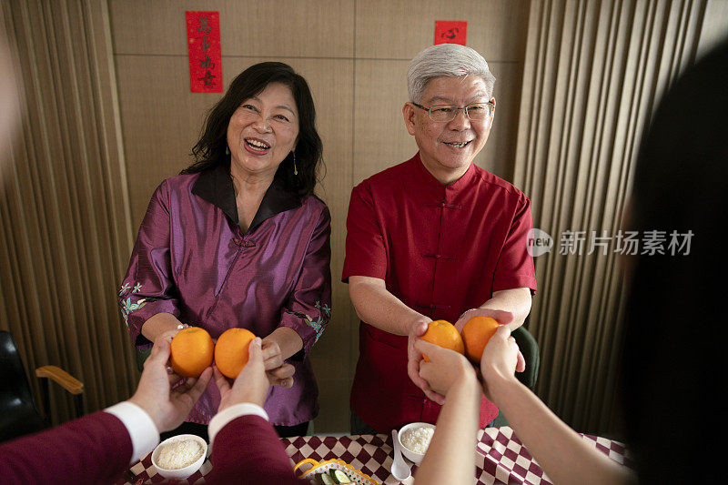 两位中国老人在接受春节祝福和橘子