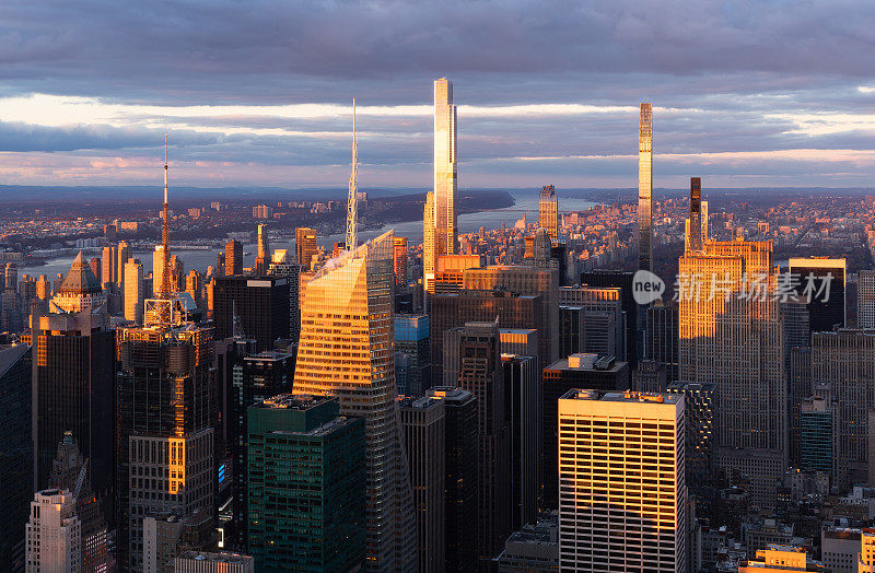 温暖的灯光照亮了曼哈顿中城亿万富翁排的超高层摩天大楼。纽约市日落时的鸟瞰图
