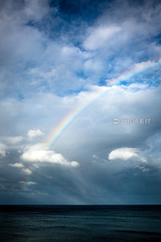 彩虹穿透云层的海景