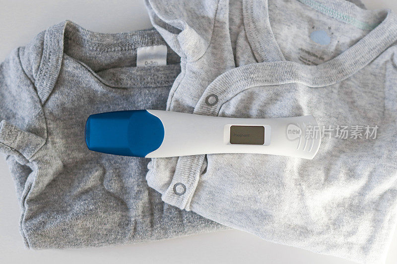 婴儿服装上的数字孕检呈阳性的特写