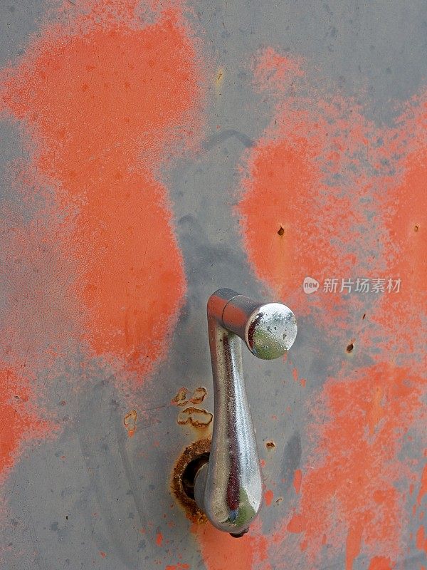 陈旧生锈的加油站泵一侧的铬曲柄