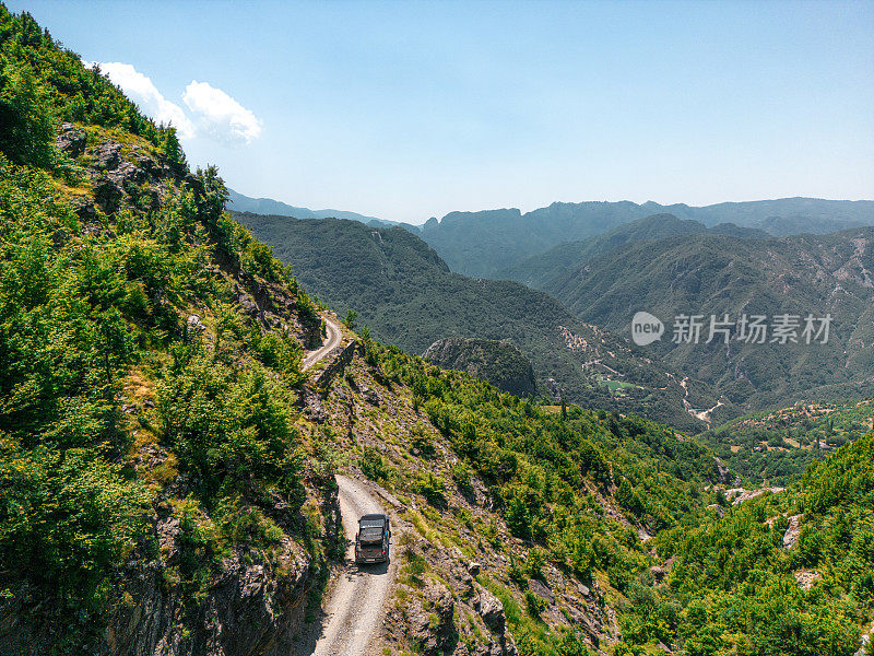 越野卡车行驶在山间狭窄道路的边缘，鸟瞰