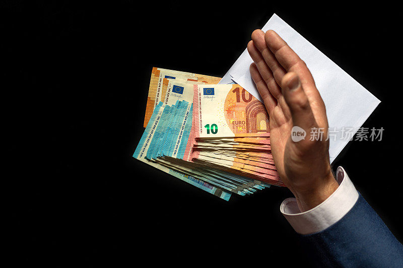 商人伸出手来成交。在他的手下面，有一个装满欧元钞票的白色信封。