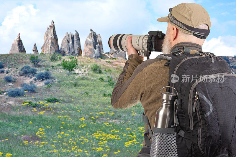 一名背着背包的旅游摄影师在山里拍摄大自然之美。大自然在山间漫步