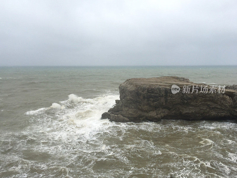 暴风雨天气中的海边悬崖。海岸线岩石，波涛汹涌的大海和多雨的天气背景