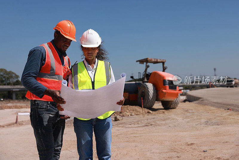 黑人工程师和工人在建筑边线绘制蓝图，基础设施