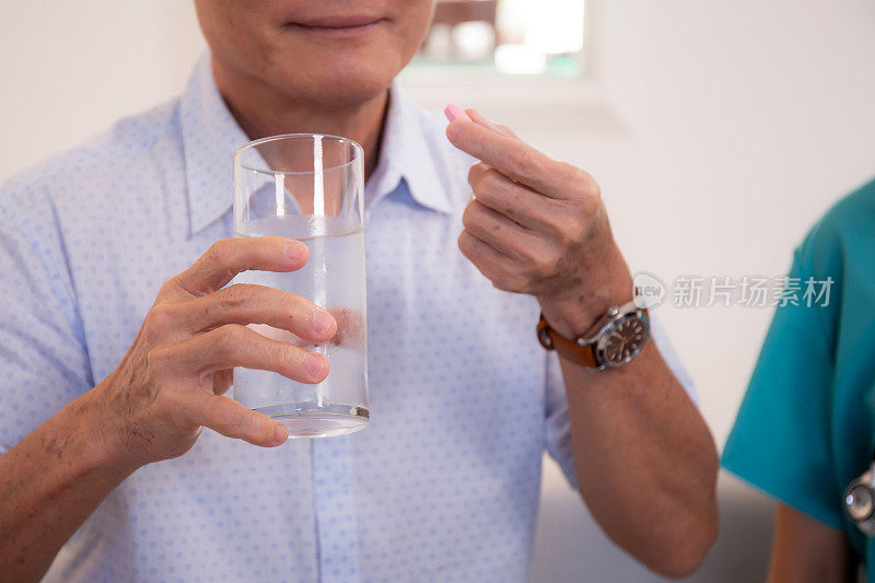 特写手病人老人服药和饮水，医疗和保险，保健和药品，老人生病和服用阿司匹林。