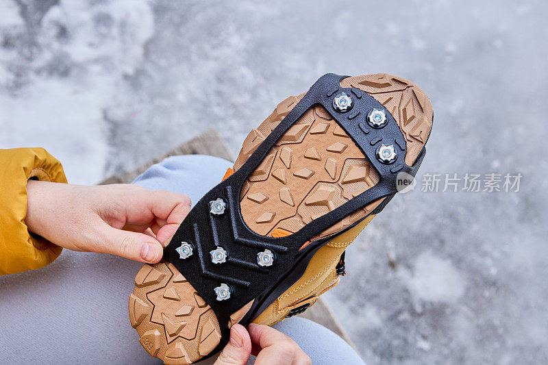 在冬天结冰的情况下，行人给鞋子穿上防滑鞋以增加牵引力。