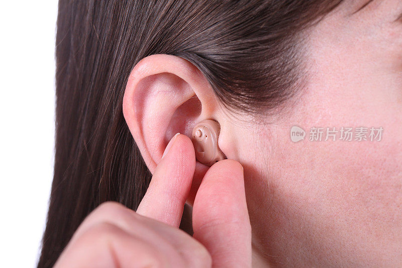 将助听器放入女性耳朵