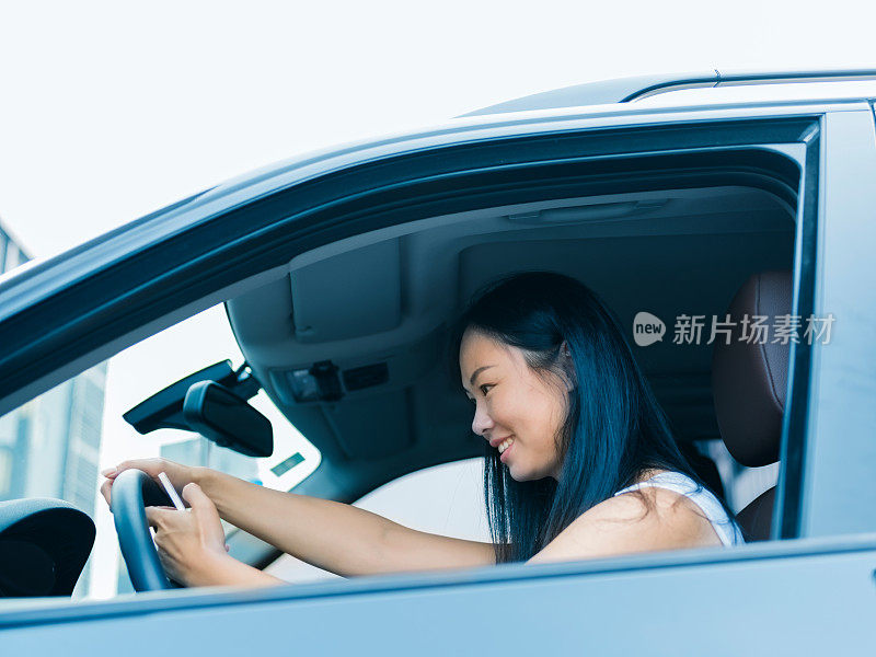 一个亚洲女人在车里检查邮箱