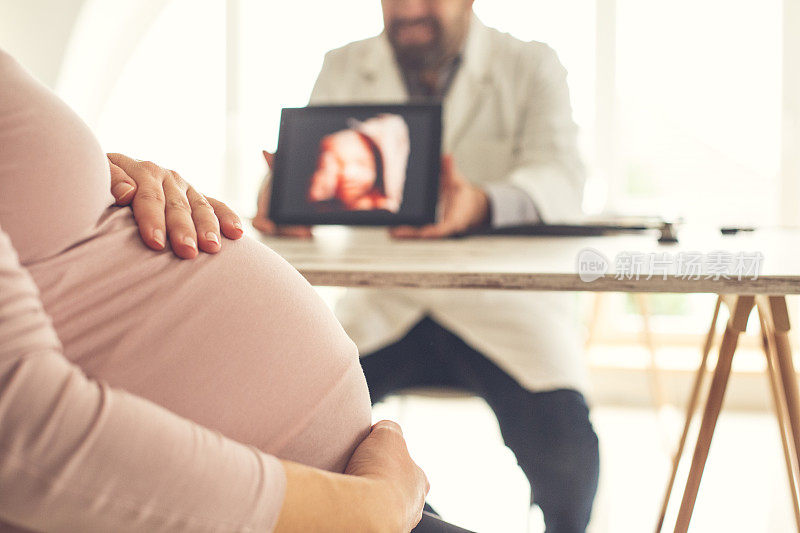 医生向孕妇展示婴儿的超声波图像