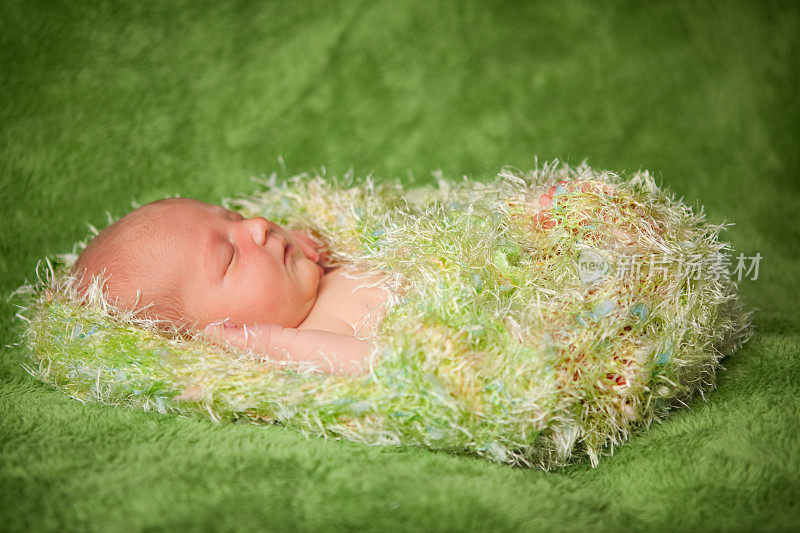 新生婴儿在毛茸茸的毯子里安静地睡觉