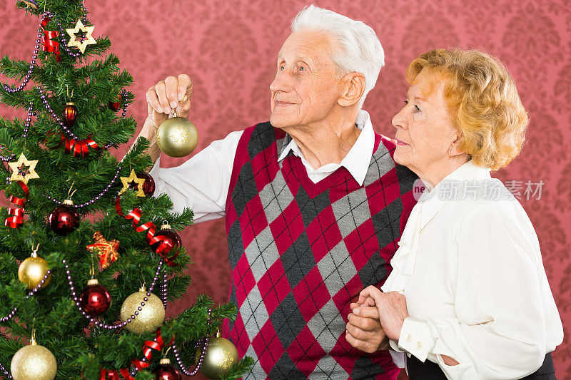 一对老年夫妇正在装饰圣诞树
