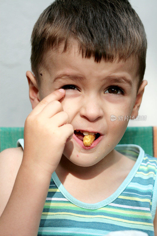 可爱的小男孩在吃玉米片
